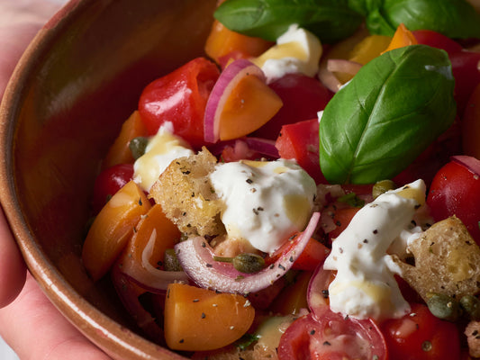 Italienischer Burrata-Salat mit Tomaten, Brotwürfeln, Zwiebeln und Basilikum